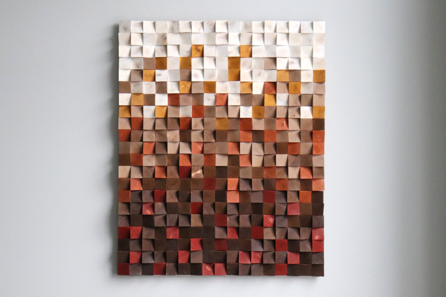 Straight-on view of handmade 3D wooden wall art with ember and caramel tones; modern interior decor.