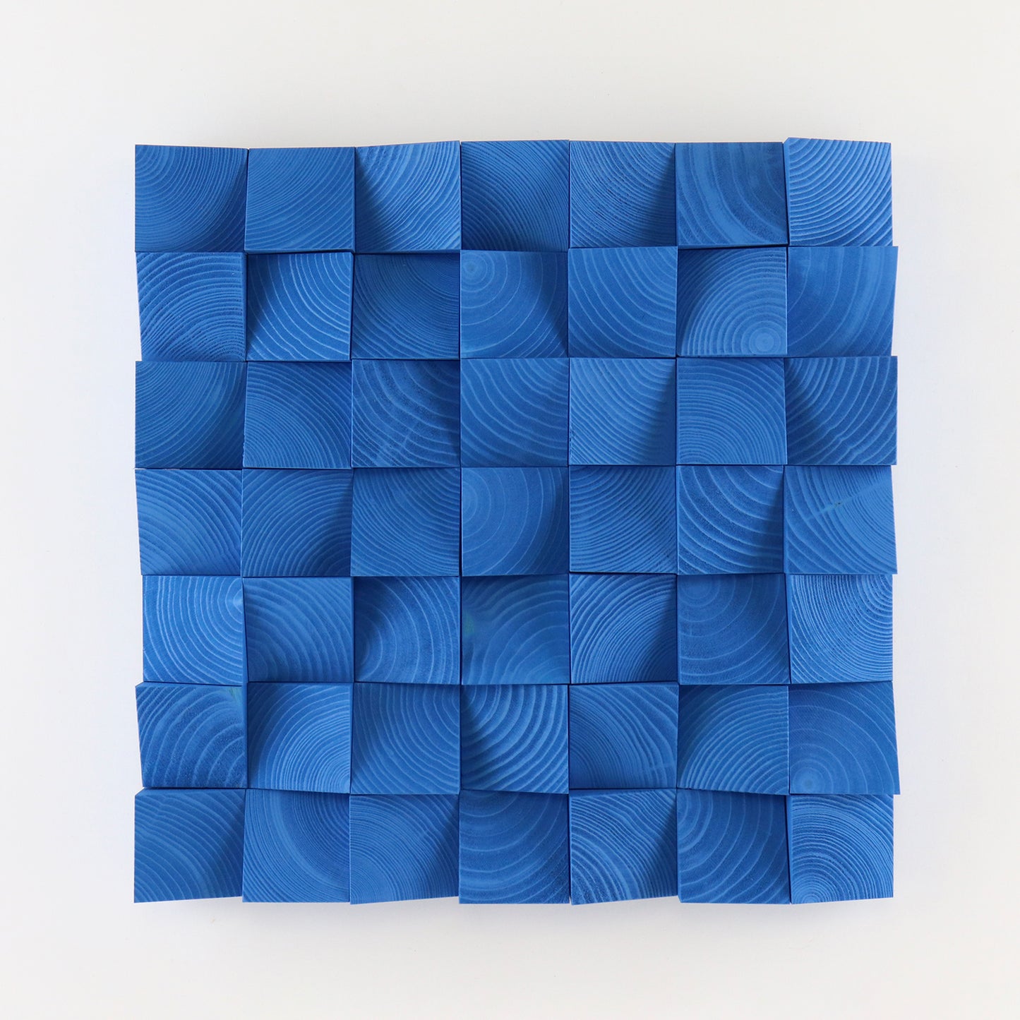 Handcrafted signal blue wooden wall art panel with sculpted 3D square blocks and visible natural wood grain texture