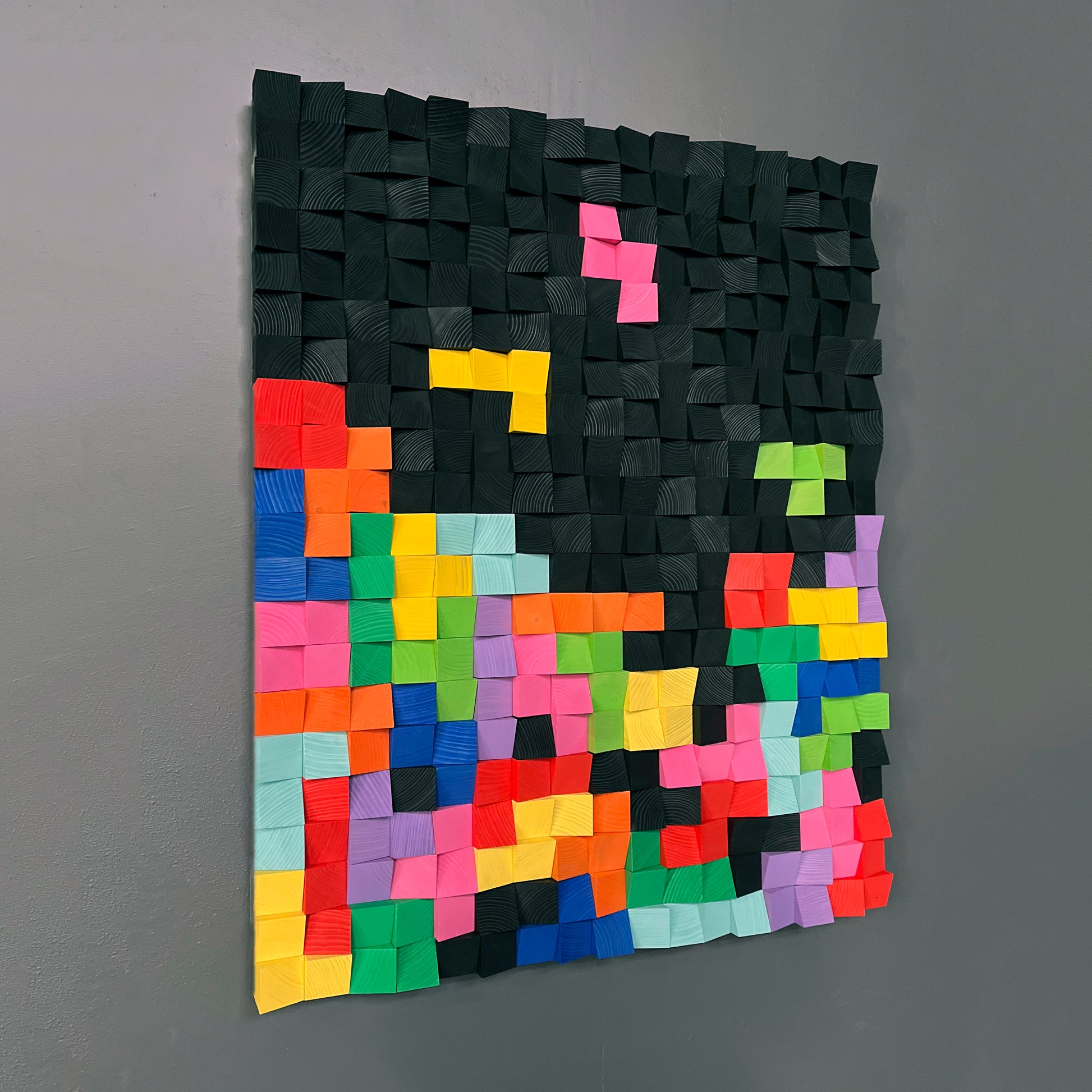 Handmade wooden wall art combining colorful shapes and black background for modern style.