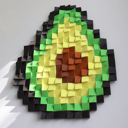 Wooden wall art shaped like an avocado slice, blending multiple green tones with a textured pit.