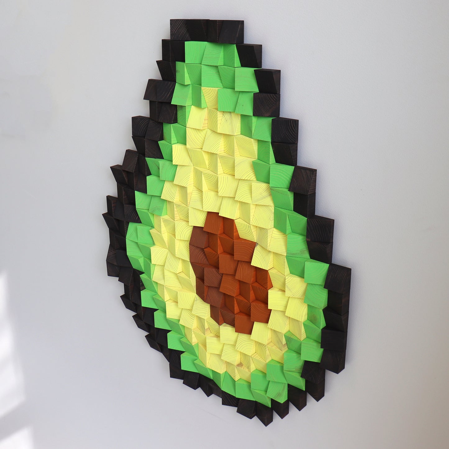 Bright 3D avocado wall decor crafted from individually painted wooden blocks.