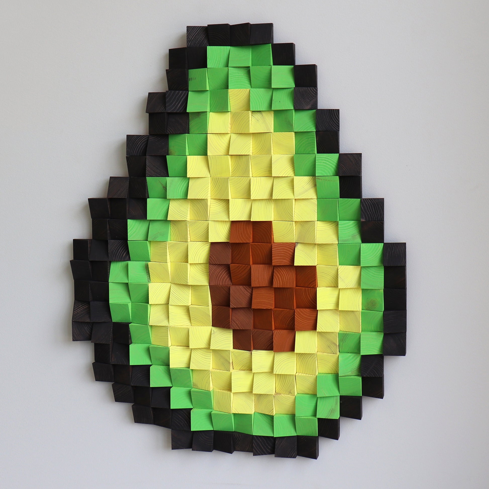 Avocado wooden wall art showing deep shadows and sculpted block shapes for a dimensional look.