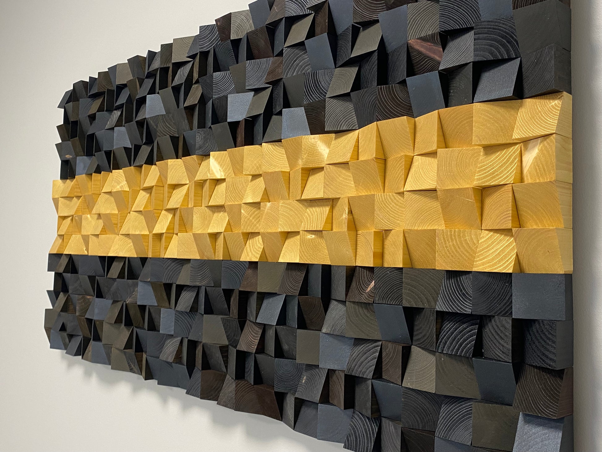 Black and gold wooden sound diffuser panel blending art and acoustic functionality.