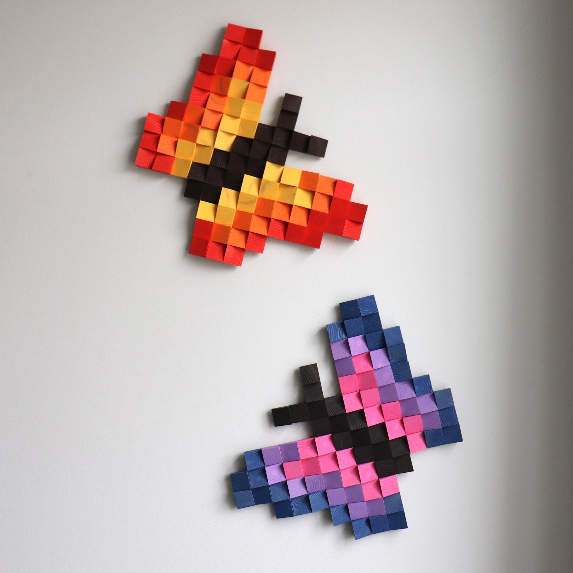 Detailed red and purple butterfly sculpture created from hand-shaped wooden blocks.