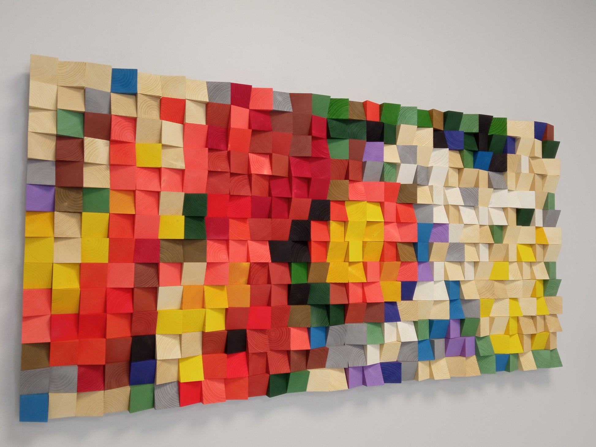 Multicolor 3D wooden wall art combining red, orange, and green tones for acoustic enhancement.