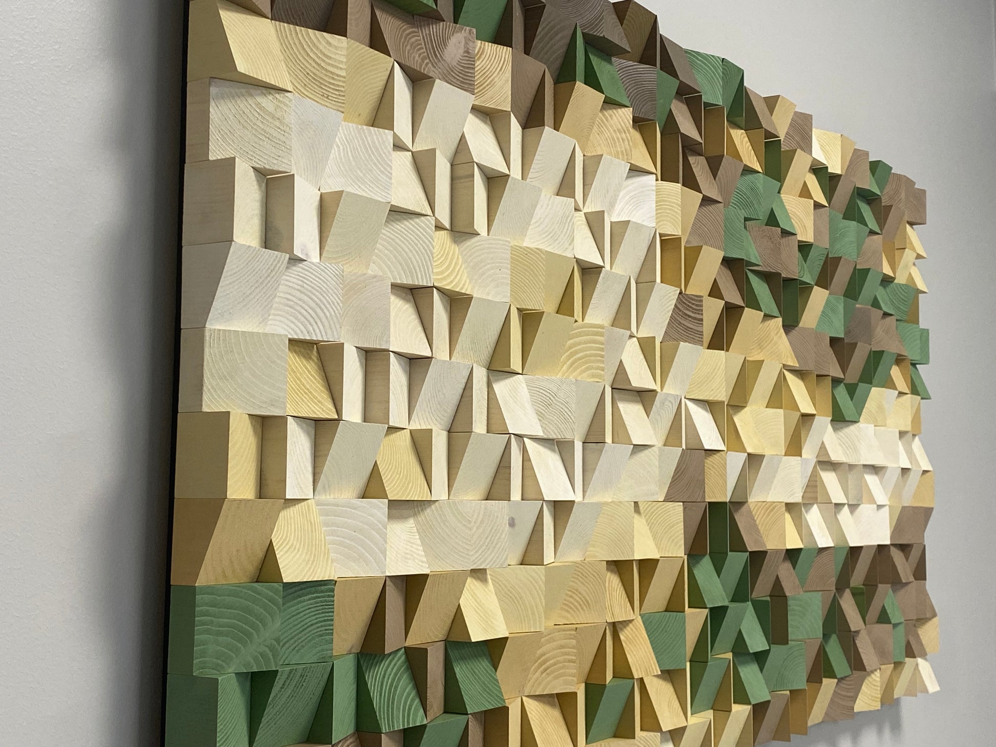 Wooden wall art piece featuring natural grain patterns in layered beige and green tones.