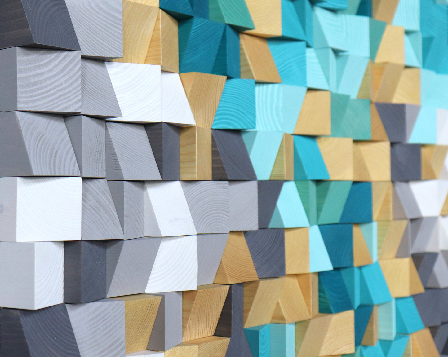 Geometric wooden acoustic wall panel crafted from natural blocks with teal and sand gradients.