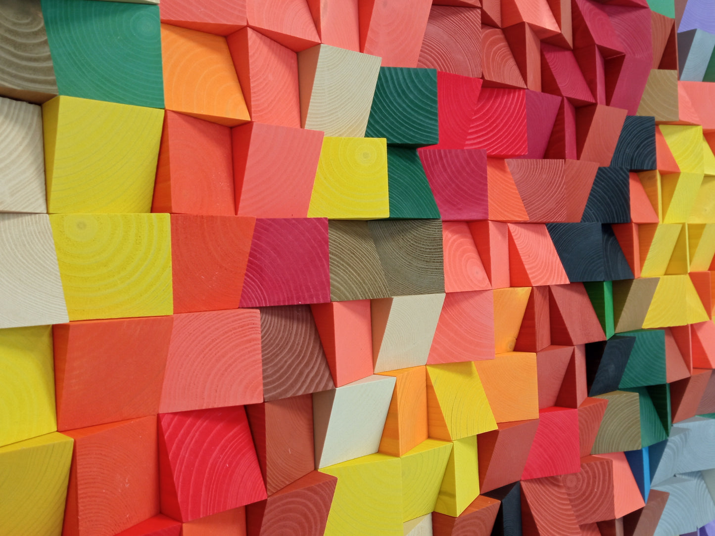 Handcrafted colorful wooden sound diffuser panel featuring bright geometric blocks in rainbow hues.