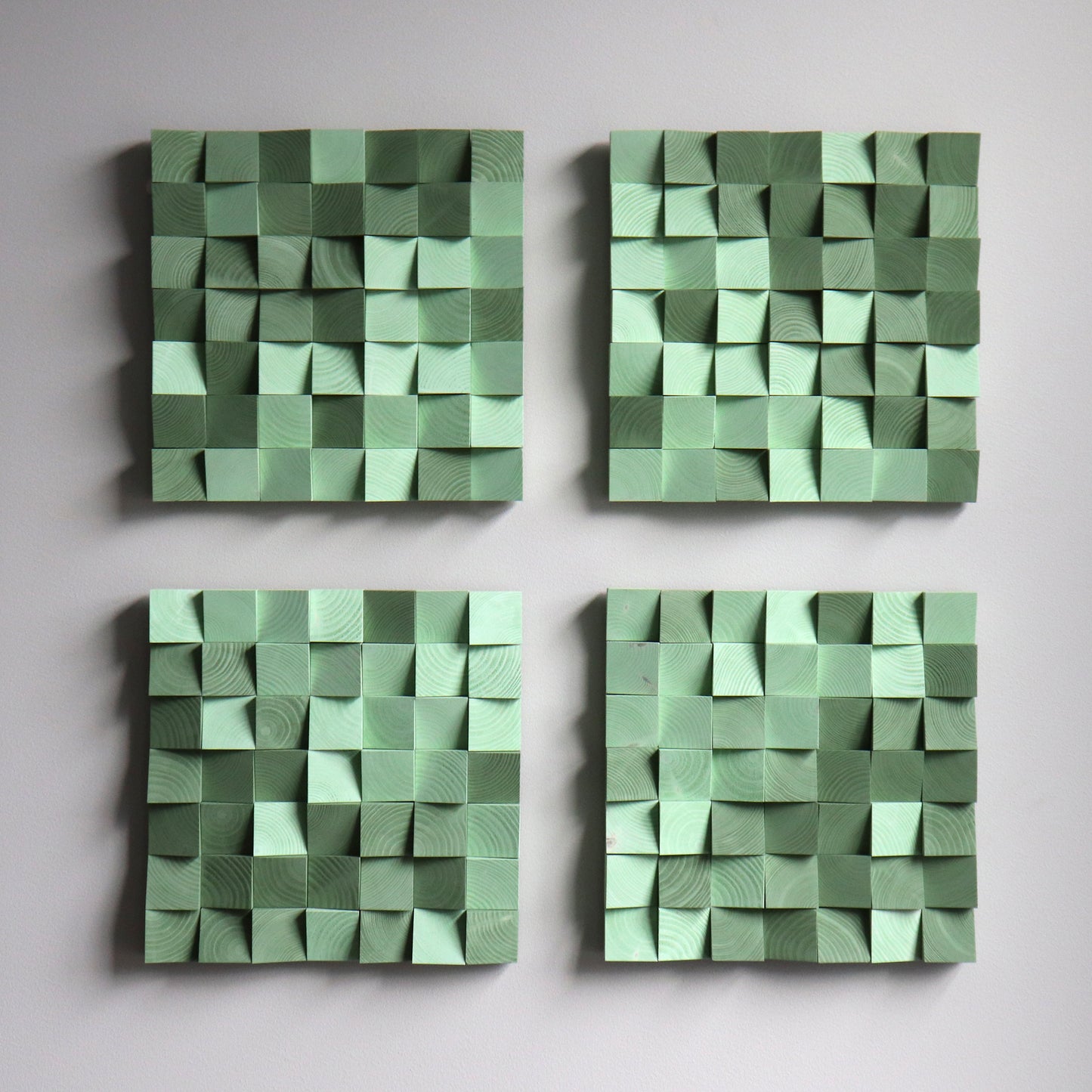 Green wooden art panel with sculpted 3D blocks and warm color palette.