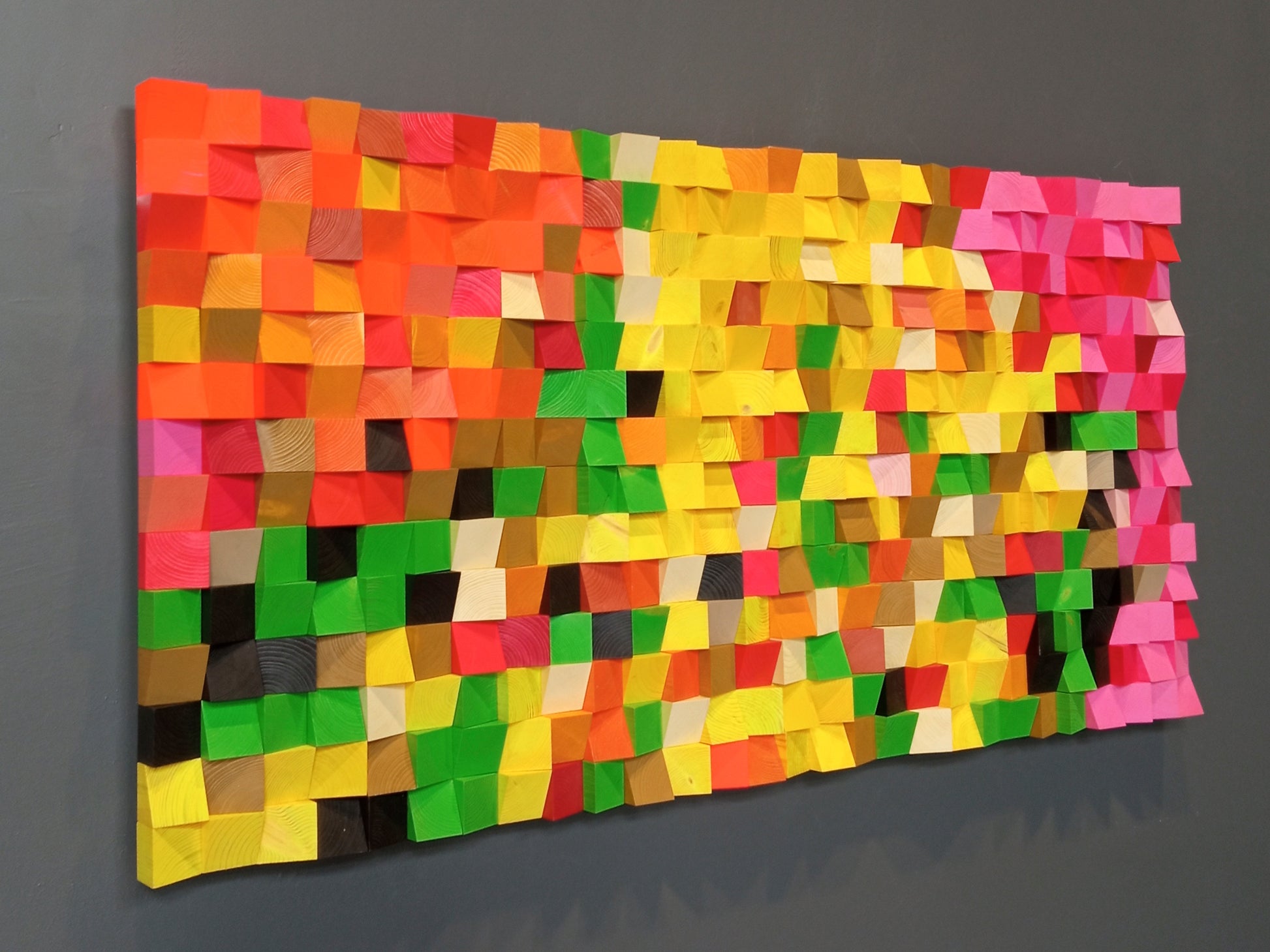 Handmade multicolor wooden acoustic panel with bold yellow, green, and pink tones for modern interior design.