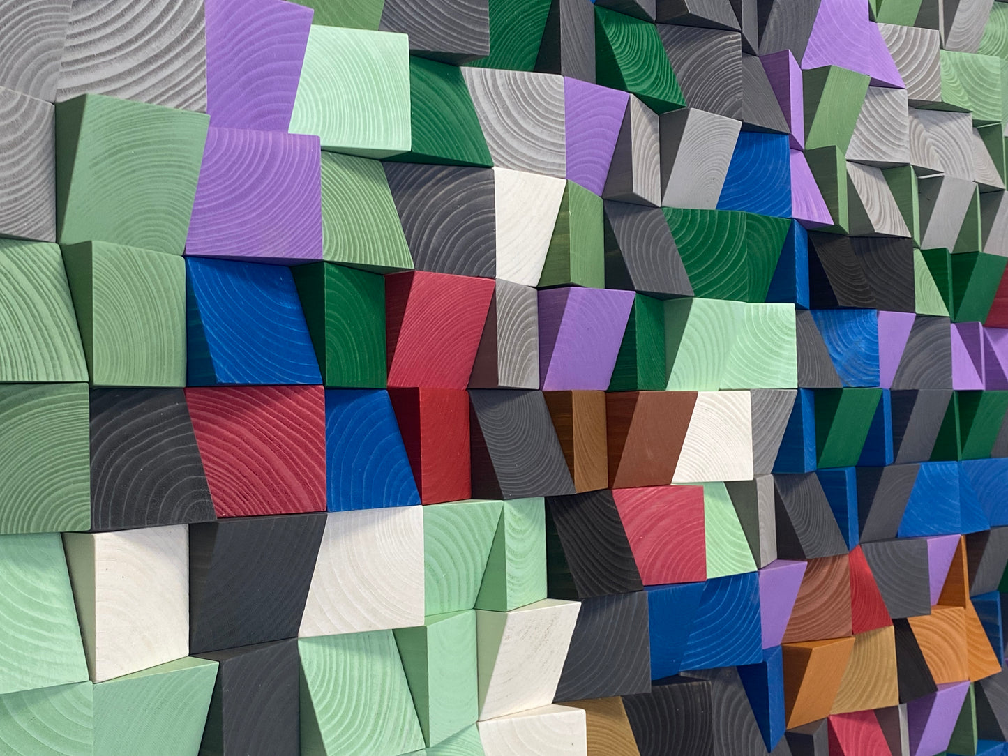 Vibrant wooden wall art sound panel with green, purple, and neutral tones for acoustic harmony.