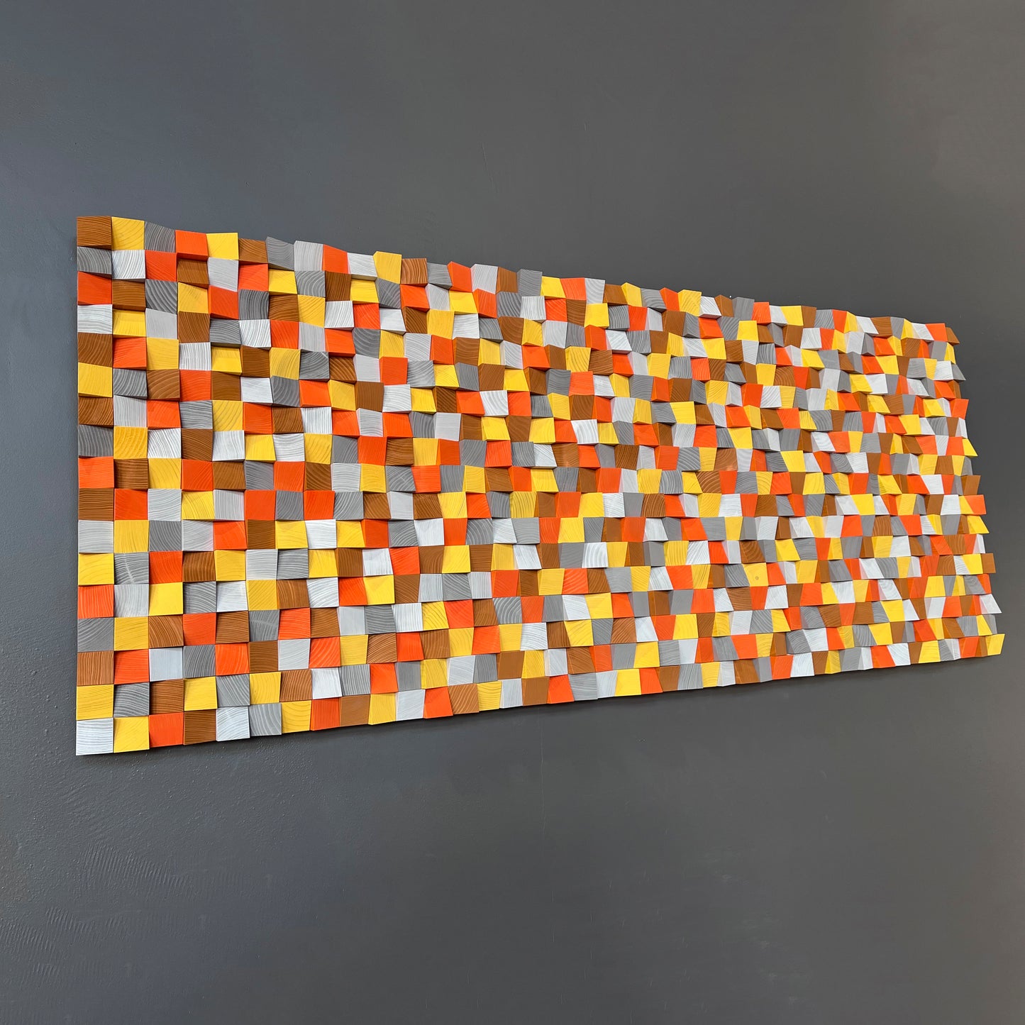 Vibrant 3D wooden wall decor with bright geometric color blocks in warm earthy hues.