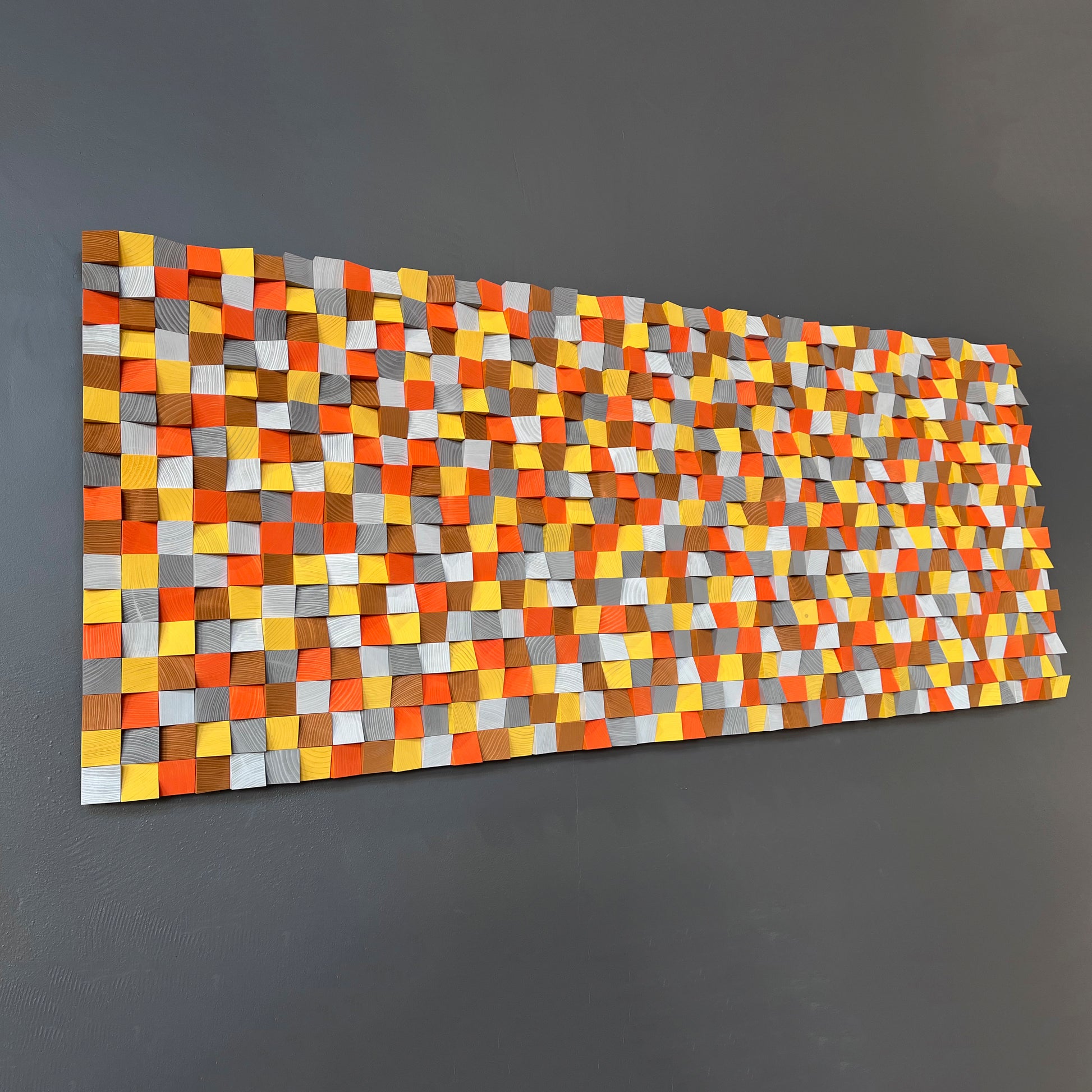 Vibrant 3D wooden wall decor with bright geometric color blocks in warm earthy hues.