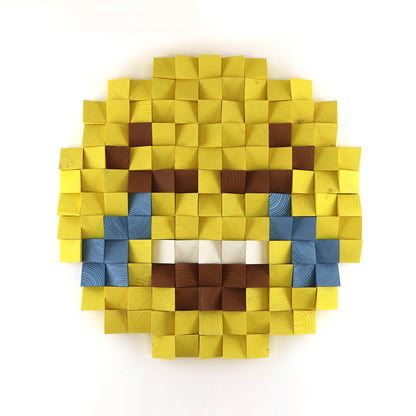 Face with tears of joy emoji 3D wooden wall art featuring blue tear details and layered yellow wooden blocks in a pixel design.