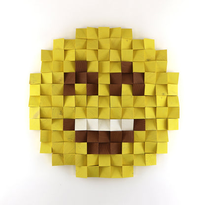 Smiling face emoji 3D wooden wall art with open mouth design made from layered yellow and brown wooden blocks.
