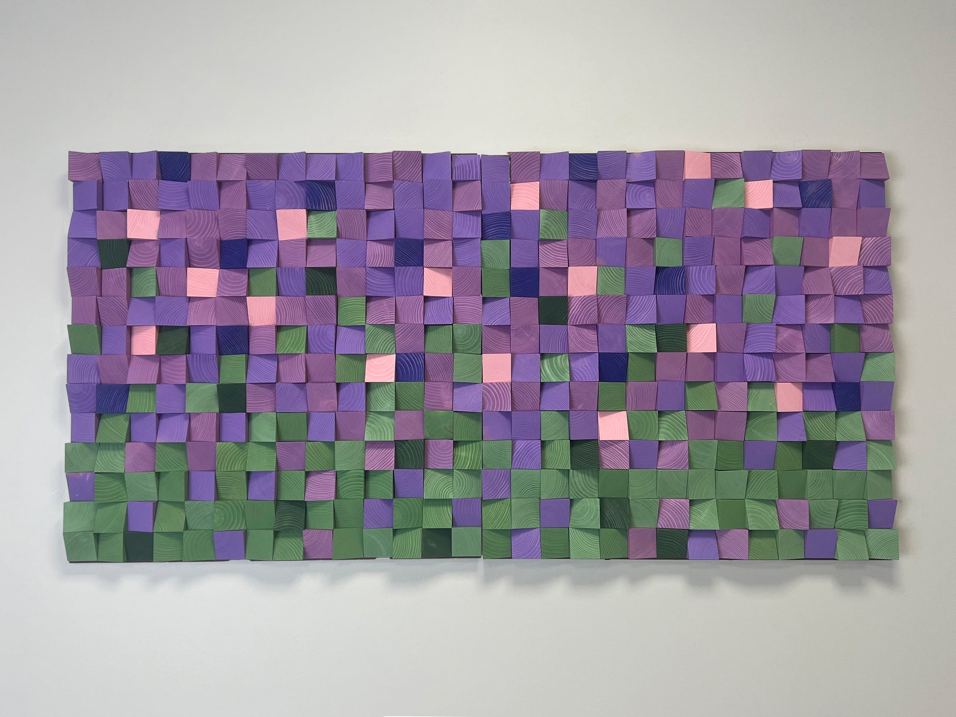 3D wooden wall art with geometric design in shades of lavender, green, and blush pink.