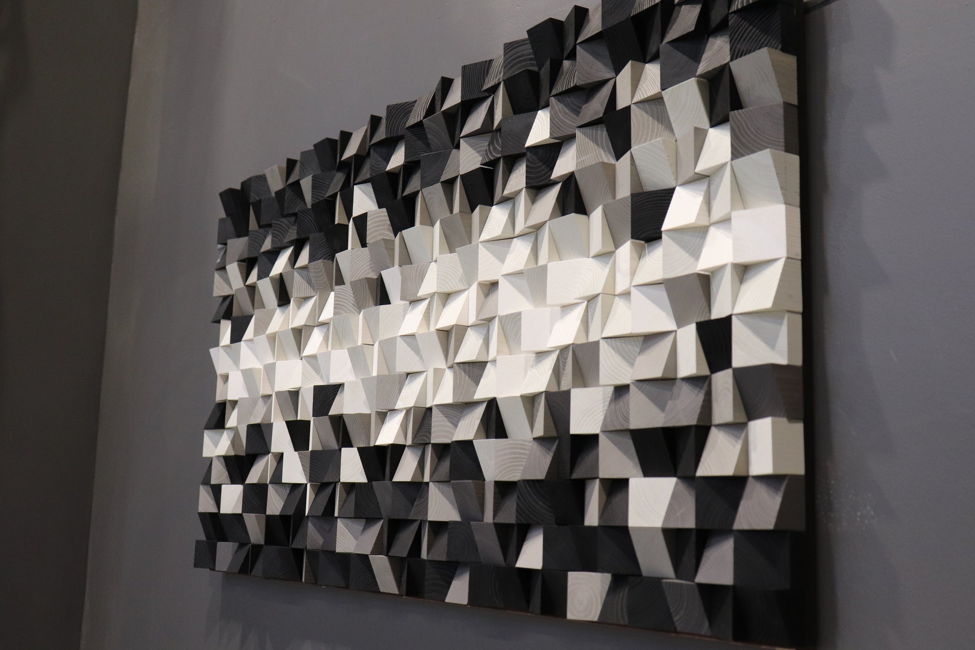 Geometric wood wall panel handcrafted from natural wood blocks painted in black and white gradients.