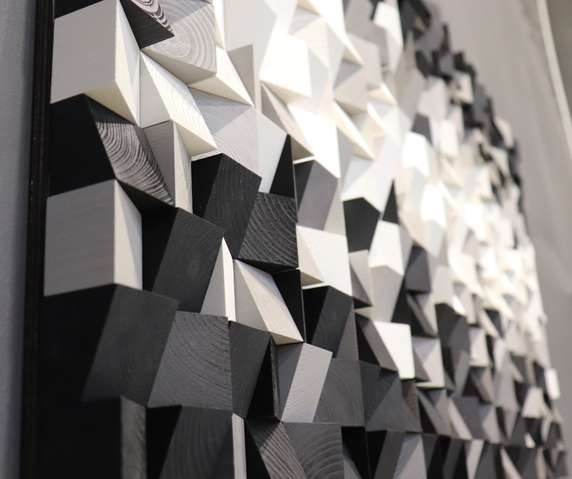Handcrafted wooden wall sculpture featuring layered geometric cubes in black, white, and grey.