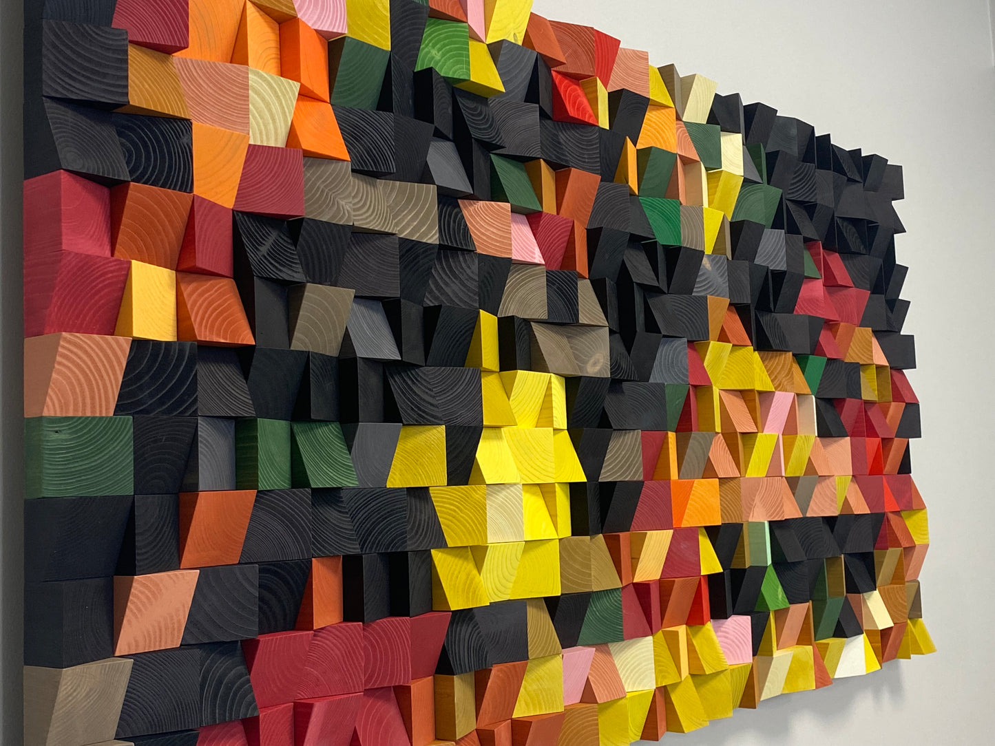 Handmade wooden wall art with pixel-style geometry and vibrant artisan-painted wood.