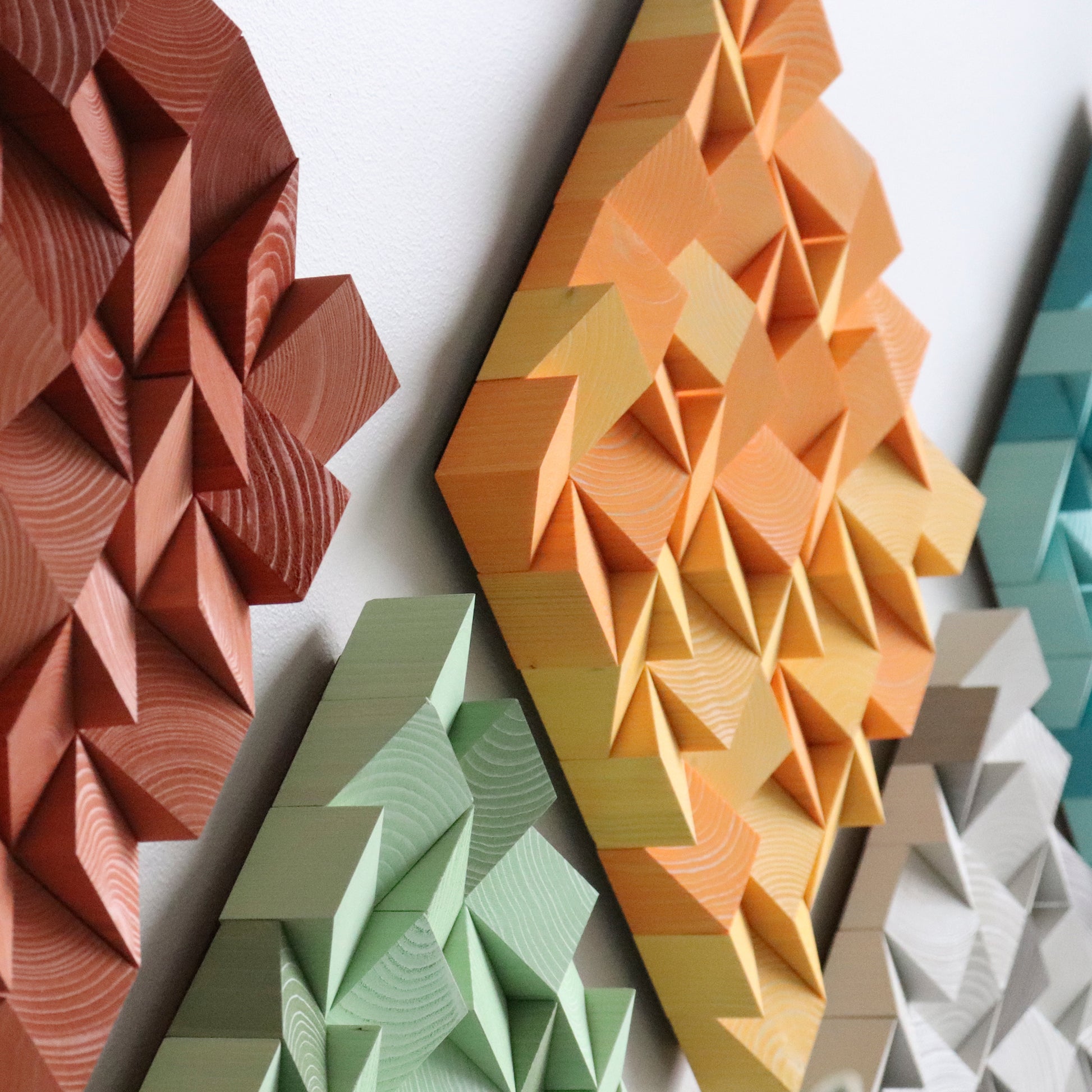 Colorful WoodenPix wall decor with mint, grey, orange, and terracotta square panels.