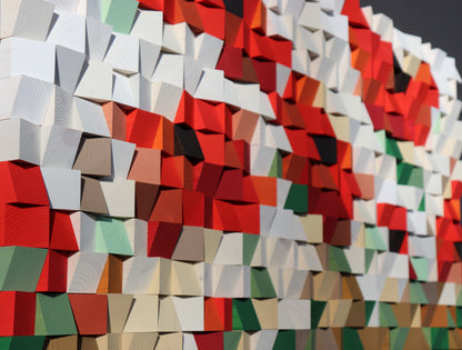 Abstract wood wall art with red, white, and green design creating a dynamic, textured surface.