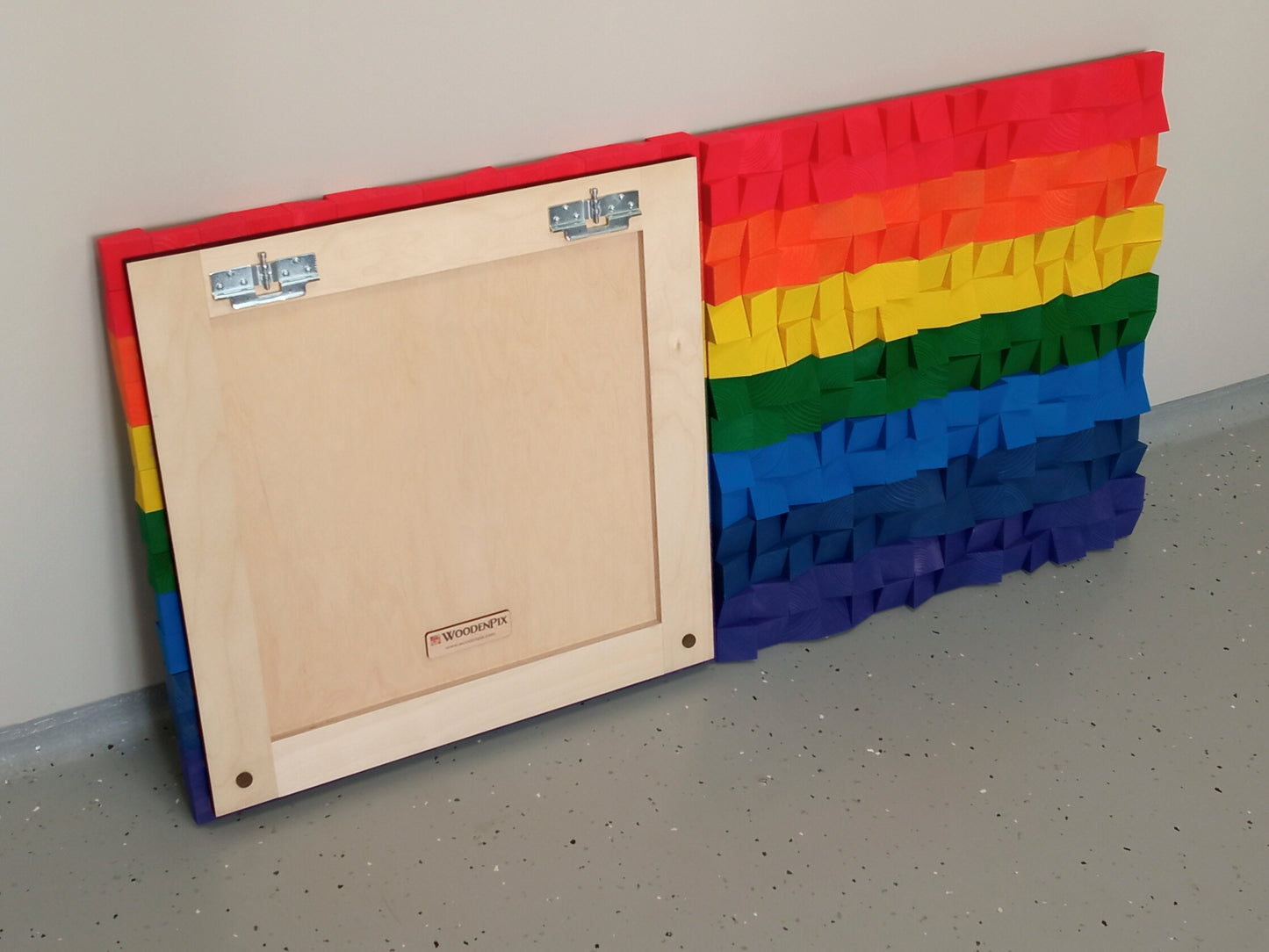 Decorative acoustic wall art made from handcrafted wooden cubes in bright rainbow tones for sound balance.