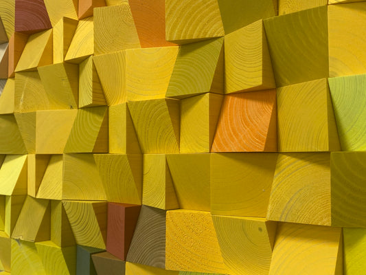 Handcrafted colorful wooden sound diffuser panel with warm autumn-inspired blocks and organic patterns.